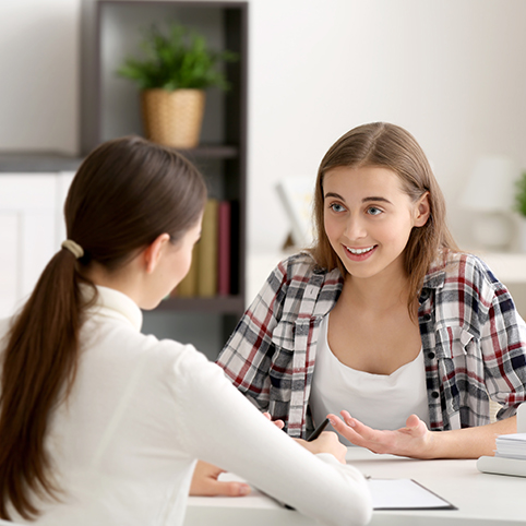 Young Girl Talking To Teacher